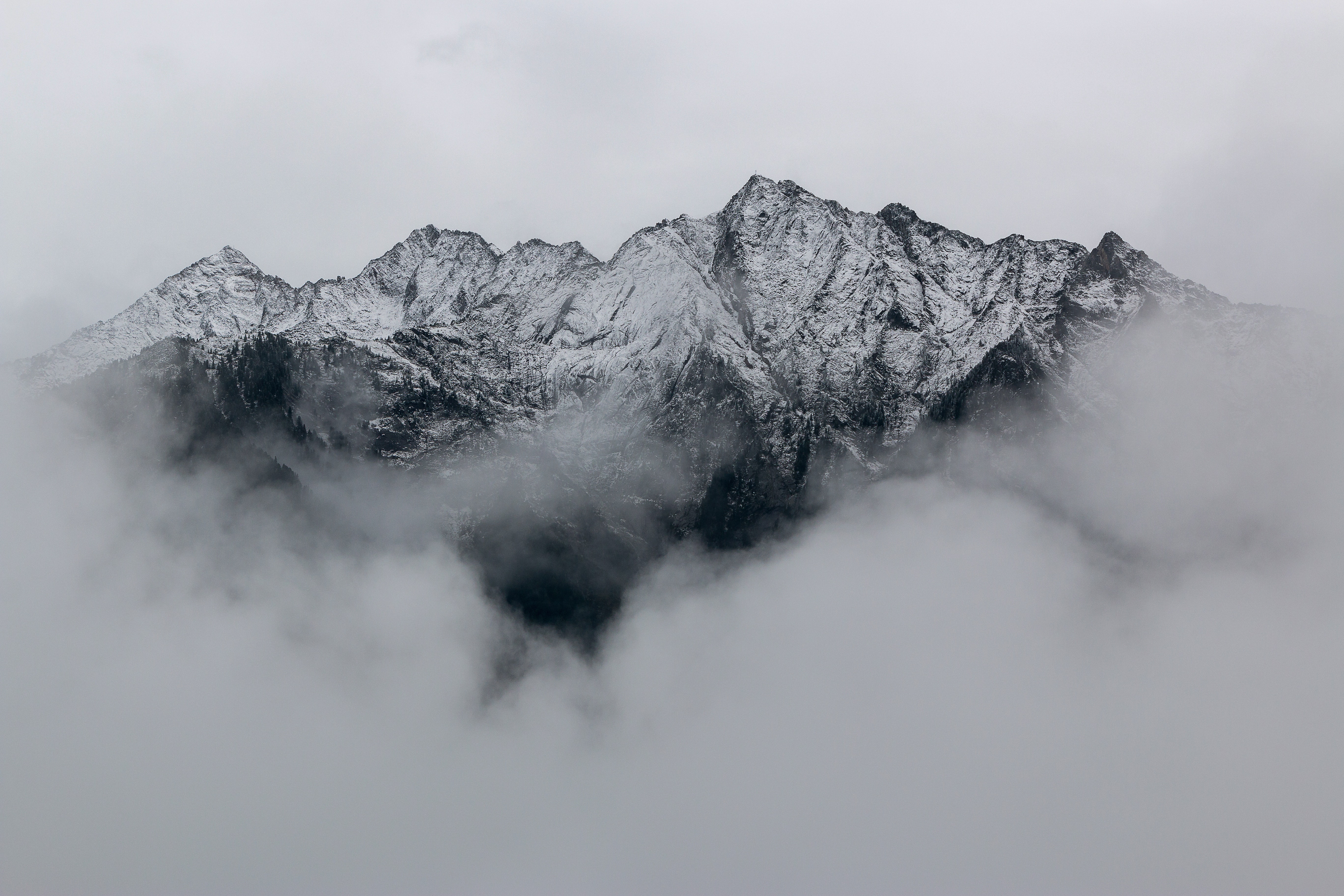 Snow-covered mountain peaks rising above the clouds