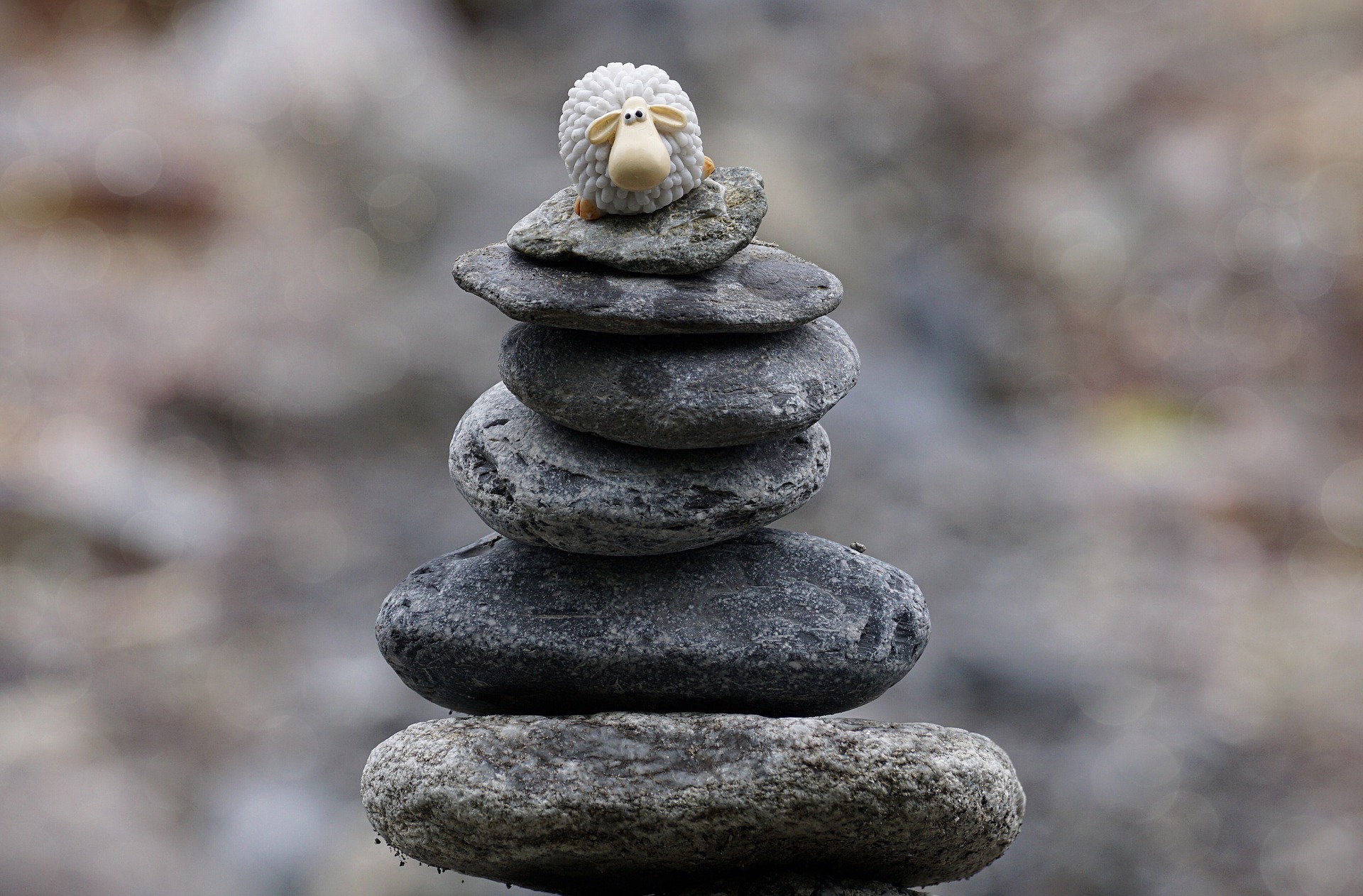 A balanced stack of stones topped with a small sheep figurine